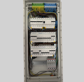 Modern breaker box with four rows, several breakers have been installed.