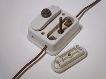 Picture of a ceramic rewireable fuse holder with the fuse holder removed, showcasing the fuse wire.