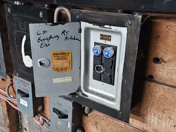 Small fuse panel with one 240V fuse and two breaker replacement fuses.