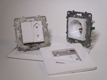 The electrical fitting from above taken apart. Items are clipped onto two support frames.