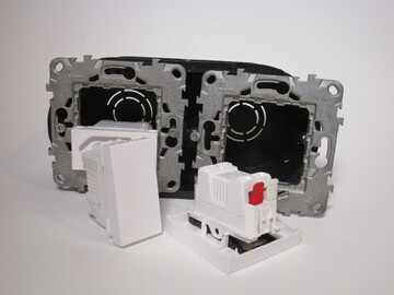Double wall box with two frames not screwed in fully, plus two switch modules in front of it.