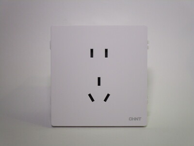Front of the socket. It's square-shaped and made of matte white plastic.