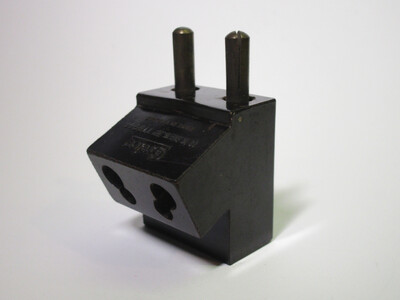 Picture of the adaptor. It is made of dark brown bakelite.
