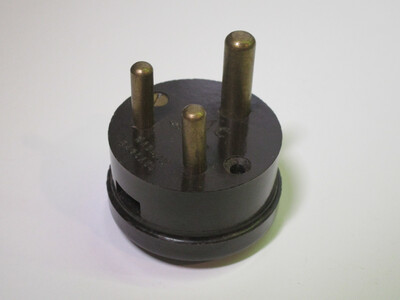 Plug view of the plug. It's made of dark brown bakelite and features an entirely round body.