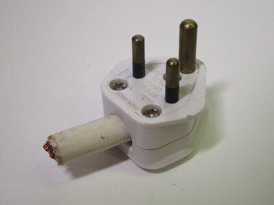 Front view of the plug. It's made of white plastic and is quite small, with the cord attached to it looking comically large by comparison.